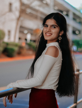 Picture of a teenage girl with dark, long hair in a white and red outfit. 