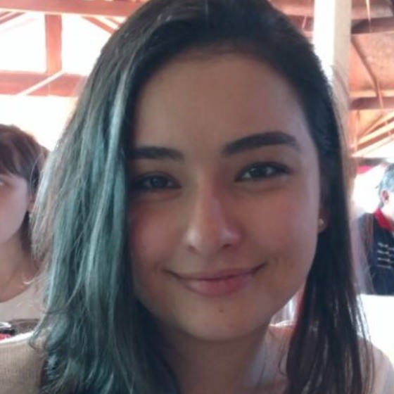 Woman with dark hair smiles at the camera. 